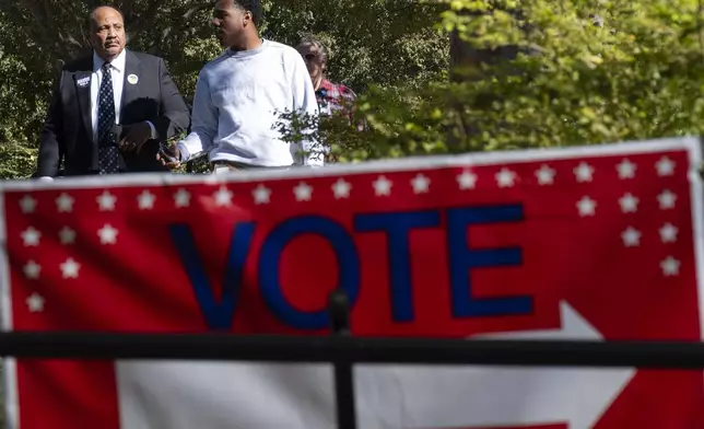 Martin Luther King III, left, walks away from a press conference after casting their early vote in Atlanta, Monday, Oct. 21, 2024. (AP Photo/Ben Gray)