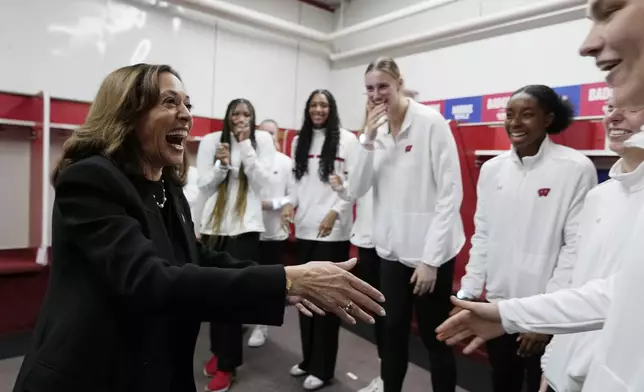 Democratic presidential nominee Vice President Kamala Harris greets the Wisconsin Badgers women's volleyball team before speaking at a campaign rally at the Alliant Energy Center in Madison, Wis., Wednesday, Oct. 30, 2024. (AP Photo/Jacquelyn Martin)