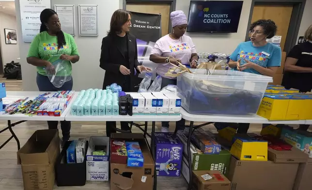 Democratic presidential nominee Vice President Kamala Harris, second left, greets workers at a food drop-off and distribution center after receiving a briefing on the damage from Hurricane Helene, Saturday, October 5, 2024, in Charlotte, N.C. (AP Photo/Chris Carlson)