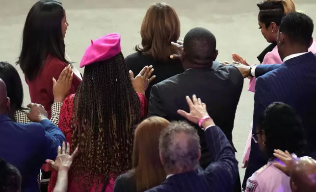 The congregation prays for Democratic presidential nominee Vice President Kamala Harris, top center, at a church service at New Birth Baptist Church in Stonecrest, Ga., Sunday, Oct. 20, 2024. (AP Photo/Jacquelyn Martin)