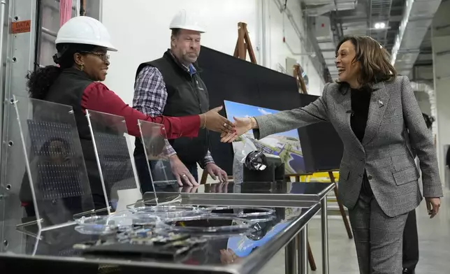 Quality control manager Janet Wolfgram, left, greets Democratic presidential nominee Vice President Kamala Harris as Harris tours the Hemlock Semiconductor Next-Generation Finishing facility in Hemlock, Mich., Monday, Oct. 28, 2024. (AP Photo/Jacquelyn Martin)