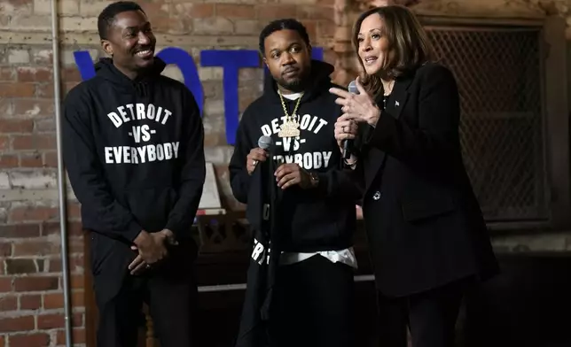 Democratic presidential nominee Vice President Kamala Harris speaks before being presented a shirt by Detroit vs Everybody co-founders Sean Xavier Williams, left, and Tommey Walker, during a stop at Cred Cafe, a local Detroit small business owned by former NBA players Joe and Jamal Crawford, in Detroit, Tuesday, Oct. 15, 2024. (AP Photo/Jacquelyn Martin)