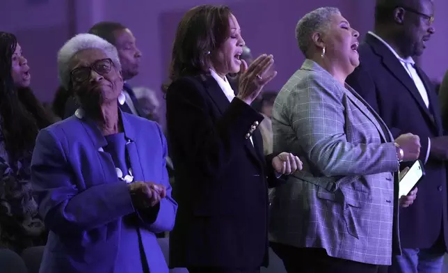 Democratic presidential nominee Vice President Kamala Harris, center, sings alongside former Rep. Eva Clayton, of North Carolina, left, and bishop Rosie O'neal, during a church service at Koinonia Christian Center in Greenville, N.C., Sunday, Oct. 13, 2024. (AP Photo/Susan Walsh)