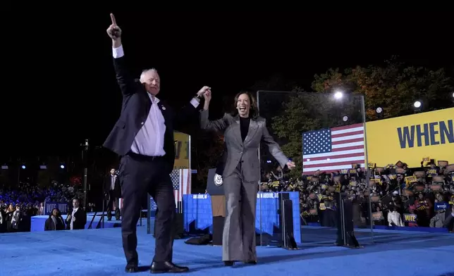 Democratic presidential nominee Vice President Kamala Harris, right, and her running mate Minnesota Gov. Tim Walz depart after speaking during a campaign rally at Burns Park in Ann Arbor, Mich., Monday, Oct. 28, 2024. (AP Photo/Paul Sancya)