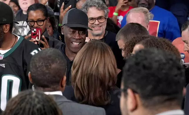 Democratic presidential nominee Vice President Kamala Harris, bottom center, greets actors Don Cheadle, top center left, and Mark Ruffalo, top center right, after speaking during a community rally at the Alan Horwitz "Sixth Man" Center, Sunday, Oct. 27, 2024, in Philadelphia. (AP Photo/Susan Walsh)