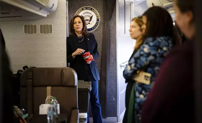 Democratic presidential nominee Vice President Kamala Harris eats Doritos and thanks senior staff aboard Air Force Two in Philadelphia, Sunday, Oct. 27, 2024. (Erin Schaff//The New York Times via AP, Pool)