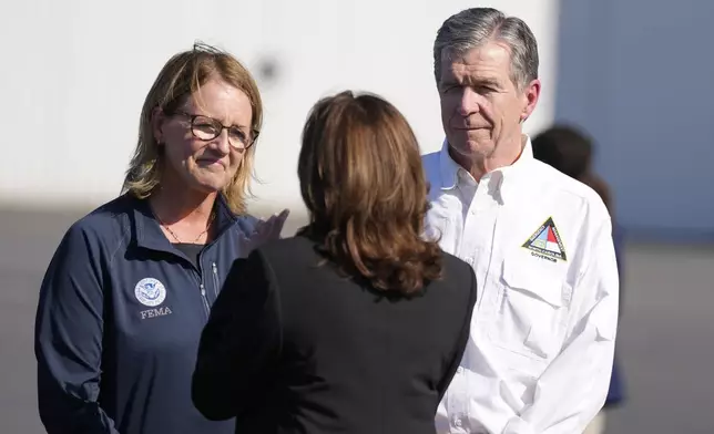 North Carolina Gov. Roy Cooper, right, and Deanne Criswell, Administrator of the U.S. Federal Emergency Management Agency, greet Democratic presidential nominee Vice President Kamala Harris at Charlotte Douglas International Airport, for a briefing on the damage from Hurricane Helene, Saturday, October 5, 2024, in Charlotte, N.C. (AP Photo/Chris Carlson)