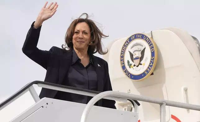 Democratic presidential nominee Vice President Kamala Harris waves as she boards Air Force Two at Detroit Metropolitan Wayne County Airport in Romulus, Mich., Friday, Oct. 4, 2024. (AP Photo/Mark Schiefelbein)