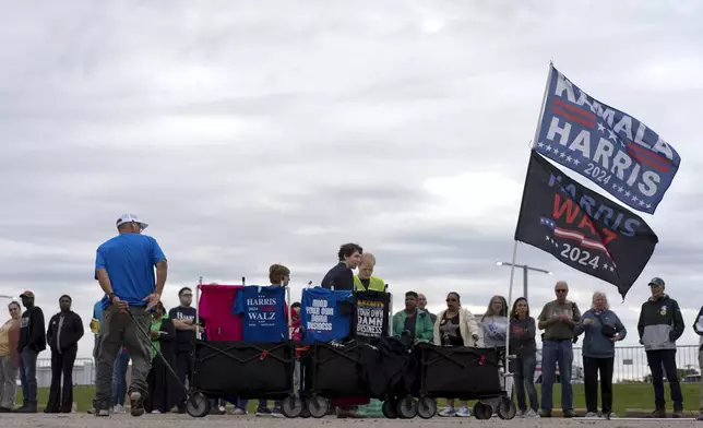 Campaign t-shirts and flags are for sale before a campaign rally for Democratic presidential nominee Vice President Kamala Harris at the Dort Financial Center in Flint, Mich., Friday, Oct. 4, 2024. (AP Photo/Carolyn Kaster)