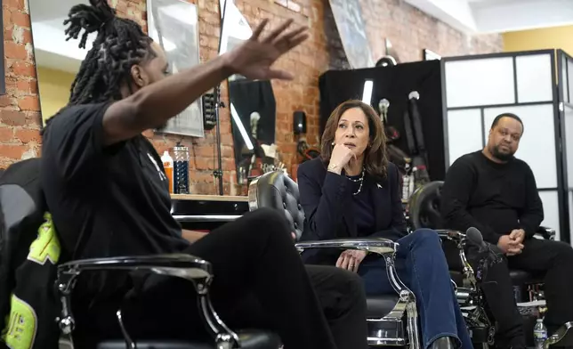 Democratic presidential nominee Vice President Kamala Harris, center, sits in conversation with Black men at Philly Cuts barbershop during a campaign stop, Sunday, Oct. 27, 2024, in Philadelphia. (AP Photo/Susan Walsh)