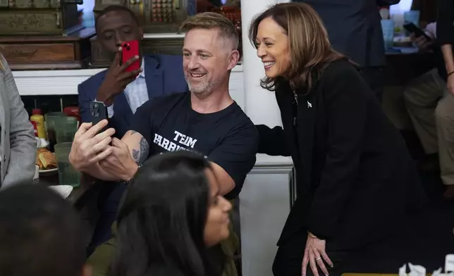 Democratic presidential nominee Vice President Kamala Harris takes a selfie with a patron at a campaign stop at Famous 4th Street Delicatessen in Philadelphia, Wednesday, Oct. 23, 2024. (AP Photo/Matt Rourke)