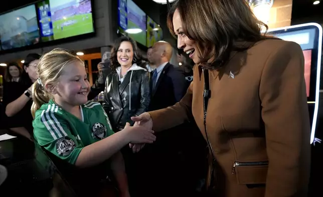 Democratic presidential nominee Vice President Kamala Harris, from right, and Michigan Gov. Gretchen Whitmer greet a young customer at the Trak Houz Bar &amp; Grill after a campaign rally in Kalamazoo, Mich. (AP Photo/Jacquelyn Martin)