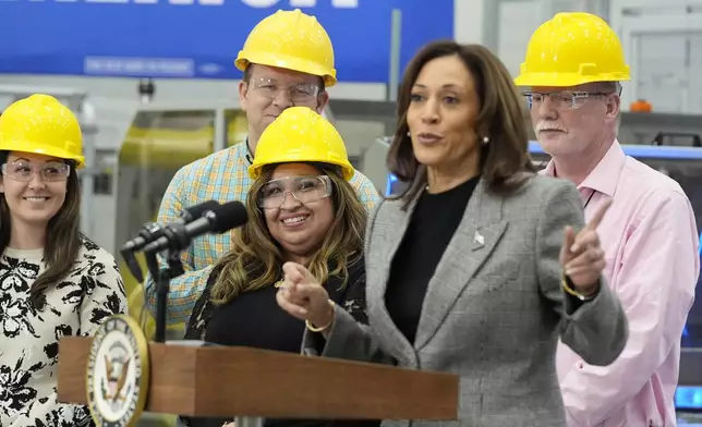 Employees watch as Democratic presidential nominee Vice President Kamala Harris speaks after taking a tour of the Hemlock Semiconductor Next-Generation Finishing facility in Hemlock, Mich., Monday, Oct. 28, 2024. (AP Photo/Jacquelyn Martin)