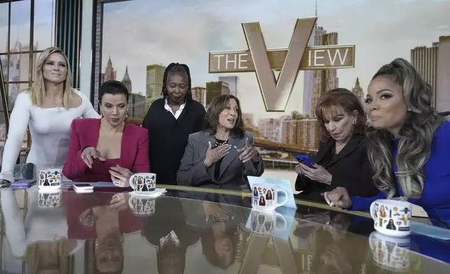 Democratic presidential nominee Vice President Kamala Harris chats with the hosts during a commercial break at The View, Tuesday, Oct. 8, 2024, in New York. From left are Sara Haines, Ana Navarro, Whoopi Goldberg, Harris, Joy Behar and Sunny Hostin. (AP Photo/Jacquelyn Martin)