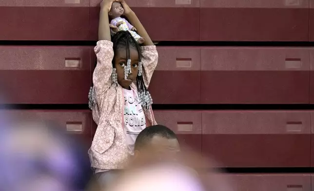 A young attendee waits for Democratic presidential nominee Vice President Kamala Harris to speak at a campaign event at Western International High School in Detroit, Saturday, Oct. 19, 2024. (AP Photo/Jacquelyn Martin)