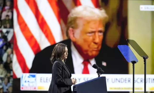 Democratic presidential nominee Vice President Kamala Harris speaks as an image of Republican presidential nominee former President Donald Trump appears on screen during a campaign rally at Erie Insurance Arena, in Erie, Pa., Monday, Oct. 14, 2024. (AP Photo/Jacquelyn Martin)