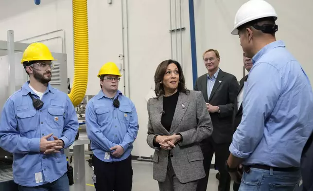 Democratic presidential nominee Vice President Kamala Harris, center, tours the Hemlock Semiconductor Next-Generation Finishing facility as Corning Chairman and CEO Wendell Weeks, second from right, looks on in Hemlock, Mich., Monday, Oct. 28, 2024. (AP Photo/Jacquelyn Martin)