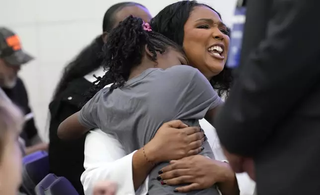 Lizzo, right, sits with a young attendee before Democratic presidential nominee Vice President Kamala Harris speaks during a campaign event at Western International High School in Detroit, Saturday, Oct. 19, 2024. (AP Photo/Jacquelyn Martin)