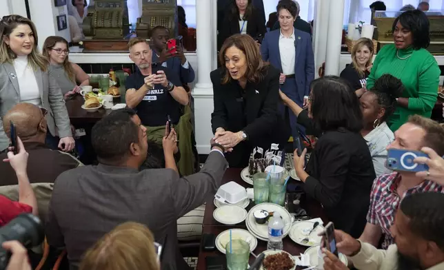 Democratic presidential nominee Vice President Kamala Harris, with Philadelphia Mayor Cherelle Parker, right, speaks to workers and patrons at a campaign stop at Famous 4th Street Delicatessen in Philadelphia, Wednesday, Oct. 23, 2024. (AP Photo/Matt Rourke)