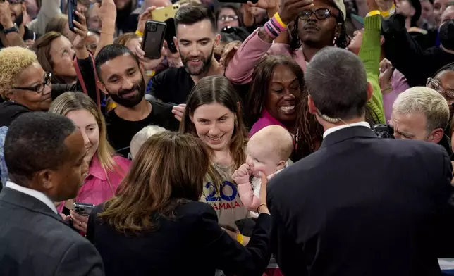 Democratic presidential nominee Vice President Kamala Harris touches a baby's cheek as she greets supporters after speaking during a community rally at the Alan Horwitz "Sixth Man" Center, Sunday, Oct. 27, 2024, in Philadelphia. (AP Photo/Susan Walsh)