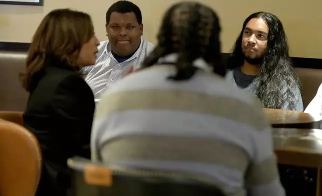 Democratic presidential nominee Vice President Kamala Harris, left, participates in a roundtable discussion with Black men during a visit to Legenderie Records and Coffee House, a Black-owned small business in Erie, Pa., during a campaign stop, Monday, Oct. 14, 2024. (AP Photo/Jacquelyn Martin)