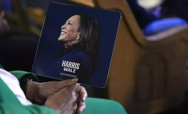 An attendee holds a campaign fan before Democratic presidential nominee Vice President Kamala Harris arrives to speak during a church service and early vote event at Divine Faith Ministries International, Sunday, Oct. 20, 2024, in Jonesboro, Ga. (AP Photo/Jacquelyn Martin)