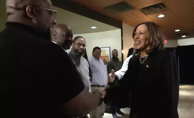 Democratic presidential nominee Vice President Kamala Harris, right, greets Ishmael Trainor, owner of Legenderie Records and Coffee House, a Black-owned small business in Erie, Pa., during a campaign stop, Monday, Oct. 14, 2024. (AP Photo/Jacquelyn Martin)