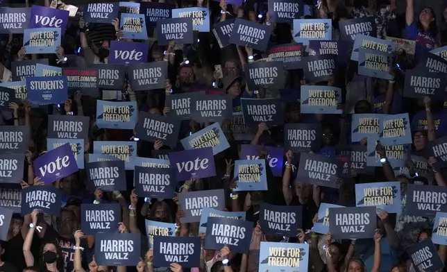 Attendees hold up signs before Democratic presidential nominee Vice President Kamala Harris arrives to speak during a campaign event at East Carolina University, Sunday, Oct. 13, 2024, in Greenville, N.C. (AP Photo/David Yeazell)