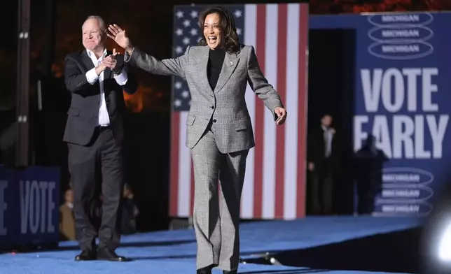 Democratic presidential nominee Vice President Kamala Harris, right, is greeted by her running mate Minnesota Gov. Tim Walz, as she arrives to speak at a campaign event in Burns Park Monday, Oct. 28, 2024, in Ann Arbor, Mich. (AP Photo/Paul Sancya)