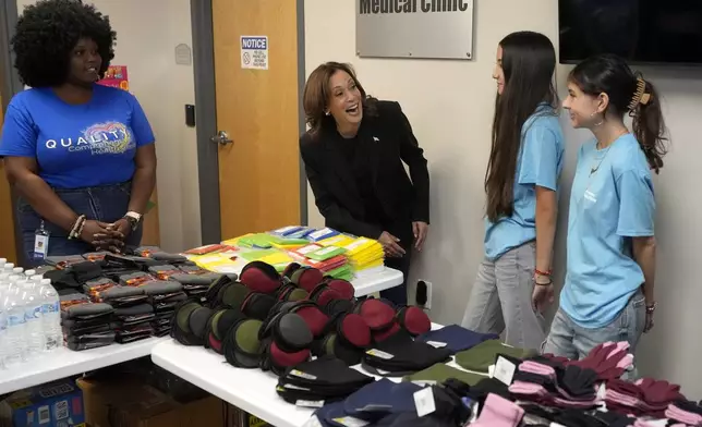 Democratic presidential nominee Vice President Kamala Harris, second left, greets workers at a food drop-off and distribution center after receiving a briefing on the damage from Hurricane Helene, Saturday, October 5, 2024, in Charlotte, N.C. (AP Photo/Chris Carlson)