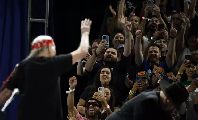 Willie Nelson waves to the crowd during a campaign rally for Democratic presidential nominee Vice President Kamala Harris, Friday, Oct. 25, 2024, in Houston. (AP Photo/Annie Mulligan)