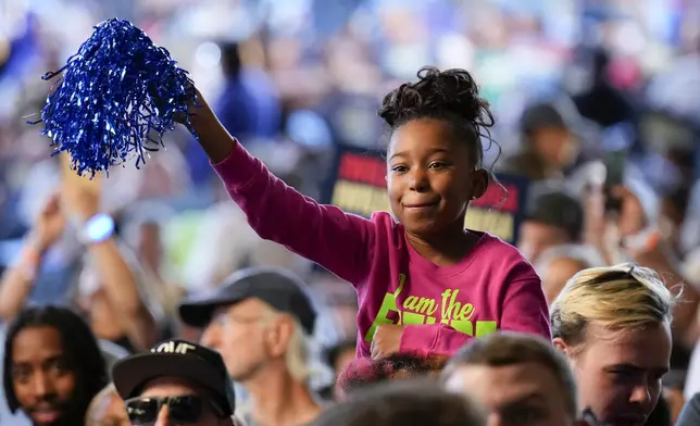 A child waves a blue pom pom during a campaign event for Democratic presidential nominee Vice President Kamala Harris speaks at Lakewood Amphitheatre, Saturday, Oct. 19, 2024, in Atlanta. (AP Photo/Jacquelyn Martin)