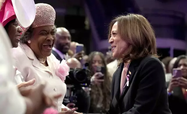 Democratic presidential nominee Vice President Kamala Harris, right, greets attendees as she arrives at a church service at New Birth Baptist Church in Stonecrest, Ga., Sunday, Oct. 20, 2024. (AP Photo/Jacquelyn Martin)