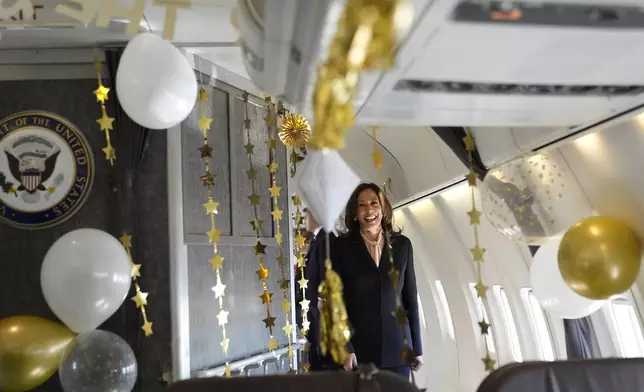 Democratic presidential nominee Vice President Kamala Harris is surprised by campaign staff with birthday decorations on Air Force Two before departing Hartsfield Jackson International Airport in Atlanta, Sunday, Oct. 20, 2024, en route to Philadelphia. (AP Photo/Jacquelyn, Martin, Pool)