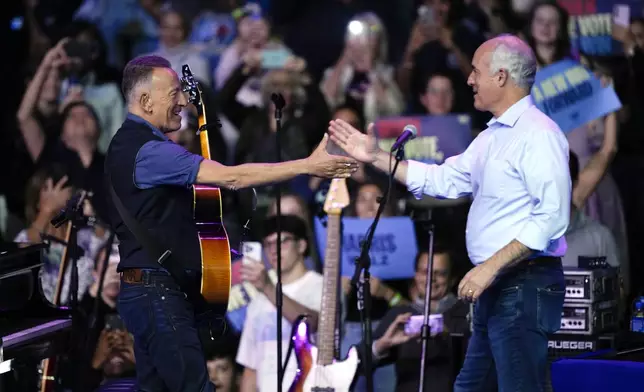 Sen. Bob Casey, D-Pa., greets Bruce Springsteen at a campaign rally with former President Barack Obama supporting Democratic presidential nominee Vice President Kamala Harris, Monday, Oct. 28, 2024, in Philadelphia. (AP Photo/Matt Rourke)