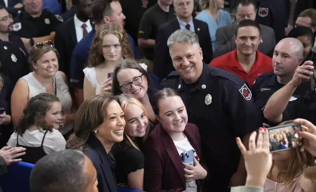 Democratic presidential nominee Vice President Kamala Harris, in foreground at left, takes a photo with attendees after speaking during an event at the Redford Township Fire Department North Station in Redford Township, Mich., Friday, Oct. 4, 2024. (AP Photo/Mark Schiefelbein)