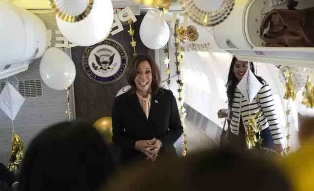 Democratic presidential nominee Vice President Kamala Harris is surprised by campaign staff with birthday decorations on Air Force Two before departing Hartsfield Jackson International Airport in Atlanta, Sunday, Oct. 20, 2024, en route to Philadelphia. (AP Photo/Jacquelyn, Martin, Pool)