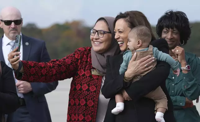 Democratic presidential nominee Vice President Kamala Harris poses for a photo with Chairwoman Nida Allam, Durham County Board of Commissioners and her son Abdul Allam Aziz, center, as Rep. Valerie Foushee, D-N.C., right, looks on, as she arrives at Raleigh–Durham International Airport in Morrisville, N.C., Wednesday, Oct. 30, 2024. (AP Photo/Susan Walsh)