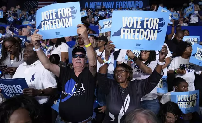 Attendees hold up signs before Democratic presidential nominee Vice President Kamala Harris arrives to speak at a campaign rally at East Carolina University in Greenville, N.C., Sunday, Oct. 12, 2024. (AP Photo/Susan Walsh)