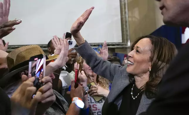 Democratic presidential nominee Vice President Kamala Harris high-fives people in the crowd after speaking at a campaign event at Lakewood Amphitheatre, Saturday, Oct. 19, 2024, in Atlanta. (AP Photo/Jacquelyn Martin)