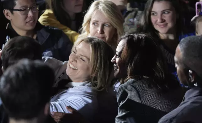 Democratic presidential nominee Vice President Kamala Harris, right, takes a selfie with a supporter after speaking at a campaign event in Burns Park Monday, Oct. 28, 2024, in Ann Arbor, Mich. (AP Photo/Paul Sancya)