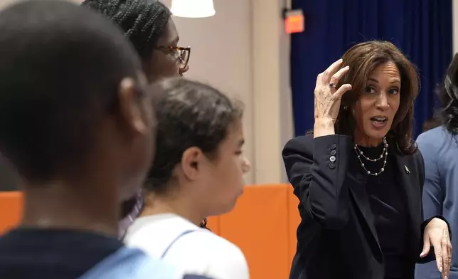 Democratic presidential nominee Vice President Kamala Harris, right, speaks with young basketball players before a community rally at the Alan Horwitz "Sixth Man" Center, Sunday, Oct. 27, 2024, in Philadelphia. (AP Photo/Susan Walsh)