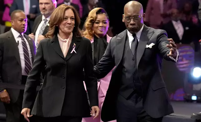 Democratic presidential nominee Vice President Kamala Harris, left, and pastor Jamal Bryant arrive at a church service at New Birth Baptist Church in Stonecrest, Ga., Sunday, Oct. 20, 2024. (AP Photo/Jacquelyn Martin)