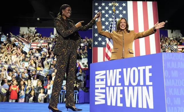 Former first lady Michelle Obama, left, and Democratic presidential nominee Vice President Kamala Harris depart after speaking at a campaign rally at the Wings Event Center in Kalamazoo, Mich. (AP Photo/Jacquelyn Martin)