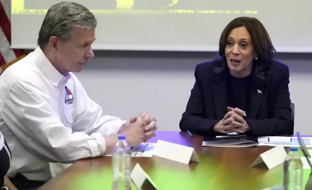 Democratic presidential nominee Vice President Kamala Harris, right, receives a briefing from North Carolina Gov. Roy Cooper on the damage from Hurricane Helene, Saturday, October 5, 2024 in Charlotte, N.C. (AP Photo/Chris Carlson)