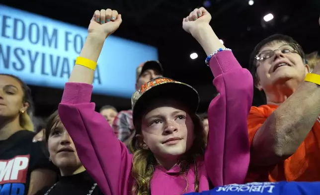 A young attendee cheers as Democratic presidential nominee Vice President Kamala Harris speaks during a campaign rally at Erie Insurance Arena, in Erie, Pa., Monday, Oct. 14, 2024. (AP Photo/Jacquelyn Martin)