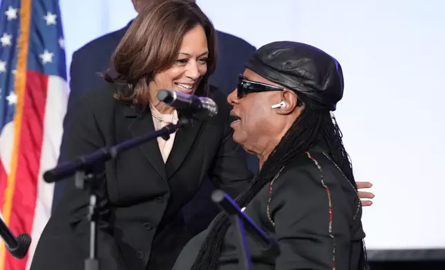 Democratic presidential nominee Vice President Kamala Harris, left, speaks with Stevie Wonder after he sang "Happy Birthday" to Harris during a church service and early vote event at Divine Faith Ministries International, Sunday, Oct. 20, 2024, in Jonesboro, Ga. (AP Photo/Jacquelyn Martin)