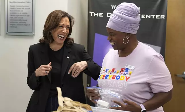 Democratic presidential nominee Vice President Kamala Harris, left, greets Melissa Funderburk, a worker at a food drop-off and distribution center, after receiving a briefing on the damage from Hurricane Helene, Saturday, October 5, 2024, in Charlotte, N.C. (AP Photo/Chris Carlson)