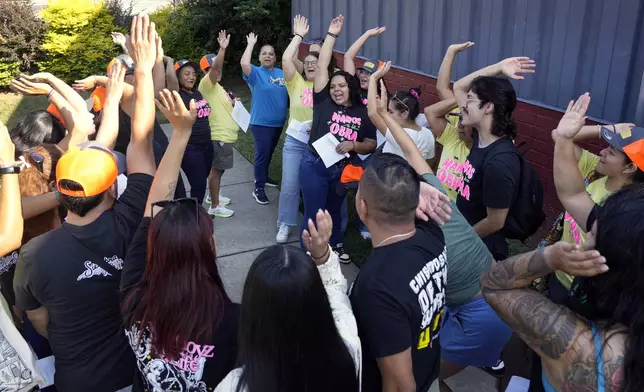 Members of a Latino support group celebrate as they meet together during a voter engagement event for the Latino community in Greensboro, N.C., Saturday, Sept. 21, 2024. (AP Photo/Chuck Burton)