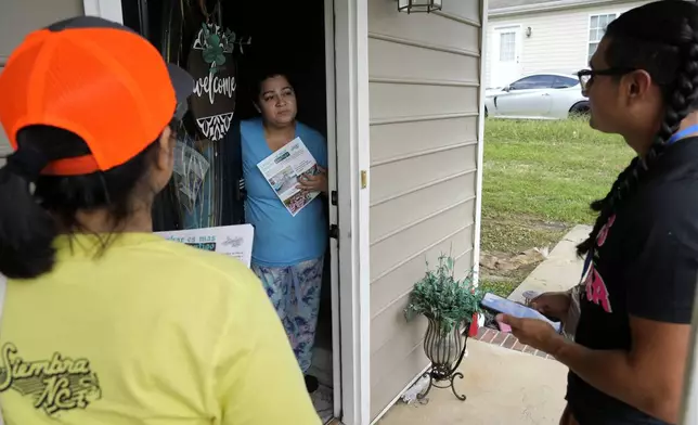 Salvador Fonseca, right, and Elena Jimenez speak with Johanna Ortiz during a voter engagement event for the Latino community in Greensboro, N.C., Saturday, Sept. 21, 2024. (AP Photo/Chuck Burton)